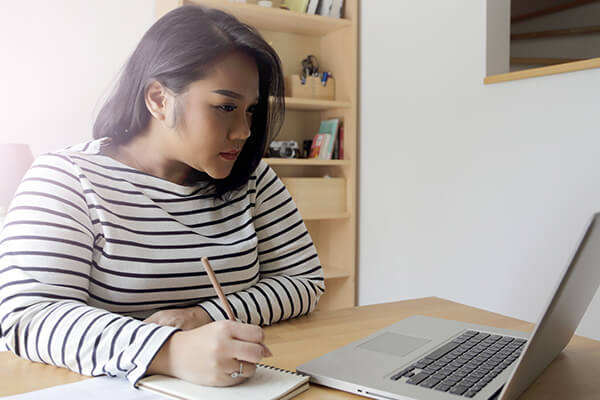 A woman sets financial goals while viewing her laptop screen