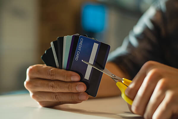 A person cuts up their credit cards 