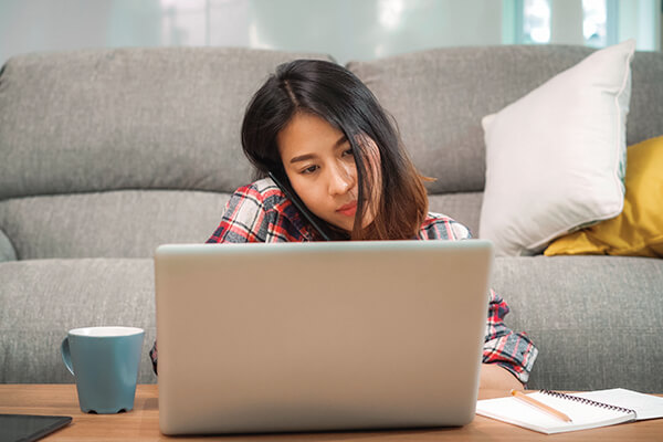 Woman on the phone, looking at her laptop