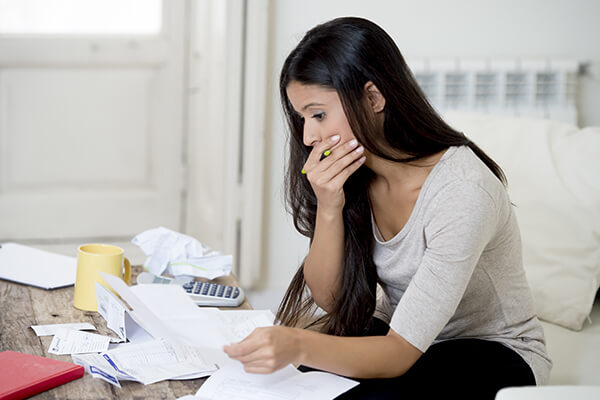 Woman going through bills, looking worried