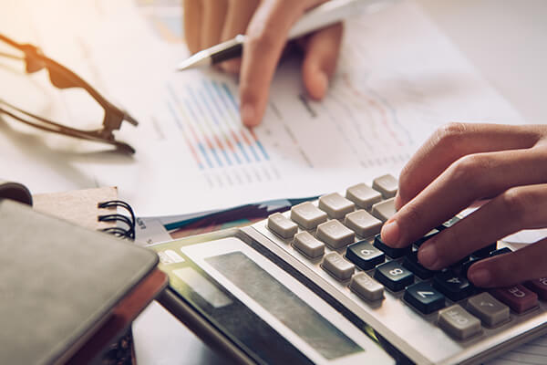 Businessman's hands with calculator and checking the financial data