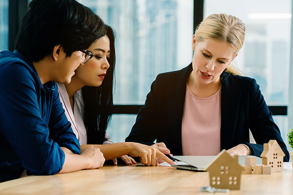 Credit counsellor woman talking to a couple during a meeting in the office.