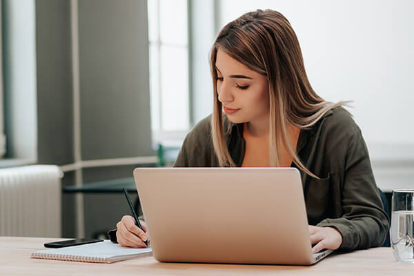 A woman creates a budget planner on her laptop. 