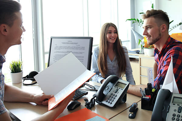 Smiling young couple sitting and talking to counselor 