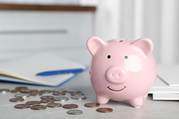 Coins around a pink piggy bank 