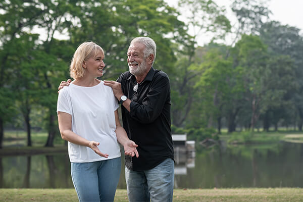 Happy mature couple walking in a park while holding each other