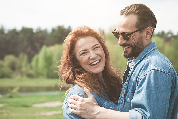 Young couple embracing, smiling at camera