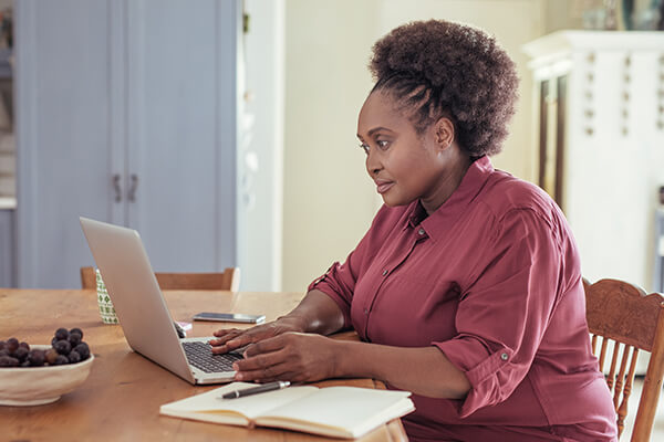 A woman resarches the long term consequences of insolvency option on her laptop.