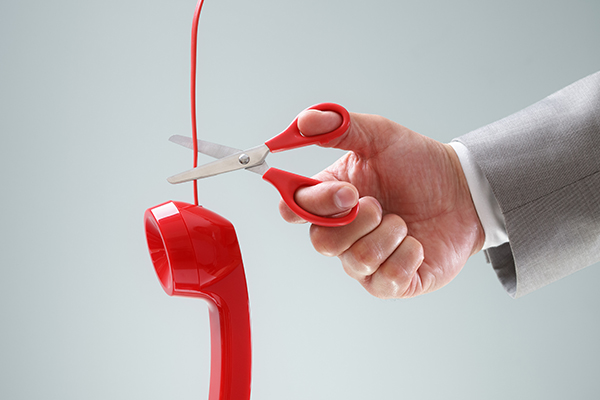 Person cutting telephone cord with scissors