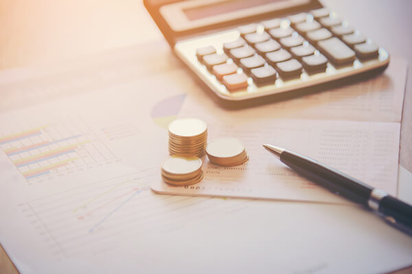 Coins stack, calculator, black pen and document paper on working table