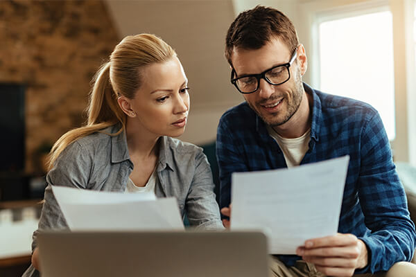 Couple looking at their finances and considering filing a consumer proposal to deal with their debts.