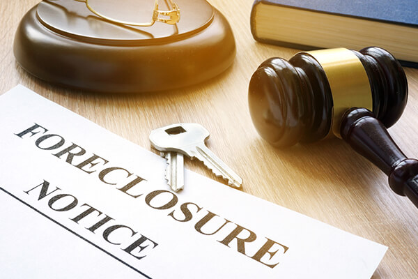 Close up of foreclosure notice document, keys and judge gavel on a table