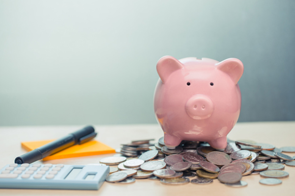 A piggy bank sits atop a pile of coins