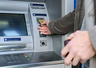 A man taking a cash advance from an ATM.