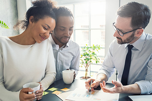 A man and a woman speaking with an accredited credit counsellor at his office.