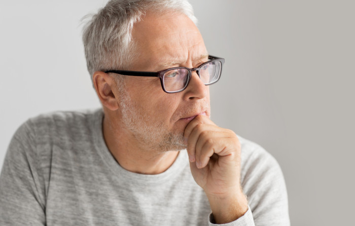 An older man thinking about a financial decision that he needs to make.