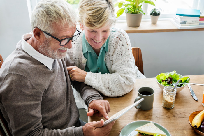 Two seniors assessing their finances on a tablet computer.