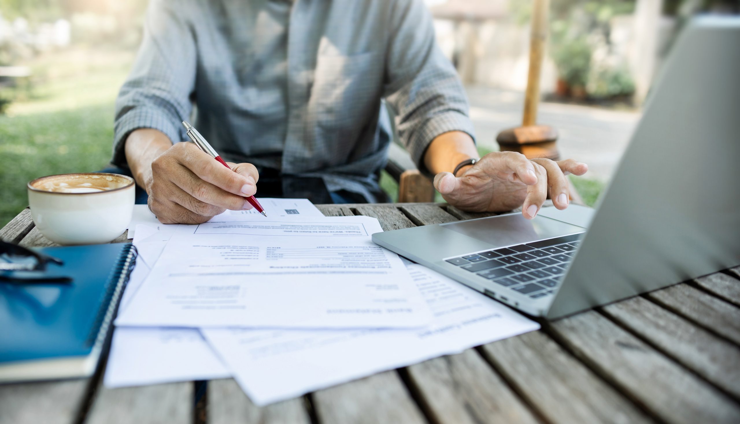 Asian Man Using Laptop Working Outdoor On Old Wooden Table In Plublic Park Checking Documents And Business Contract, Working Part Time Concept