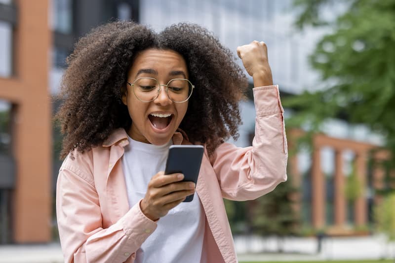Multi Genration Family Enjoying Meal In Garden To 2024 10 19 06 34 52 Utc (1) Woman cheering when winning a BNPL in-app game